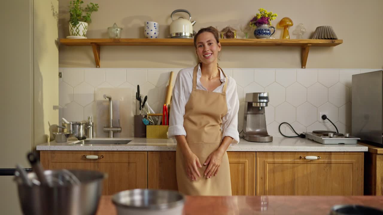 mujer en la cocina sonriendo y usando un delantal