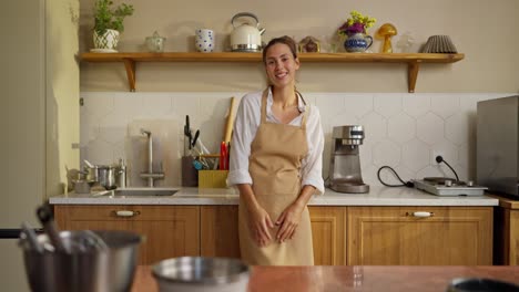 mujer en la cocina sonriendo y usando un delantal