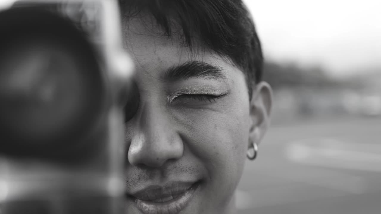 Young asian man using vintage old video camera outdoor