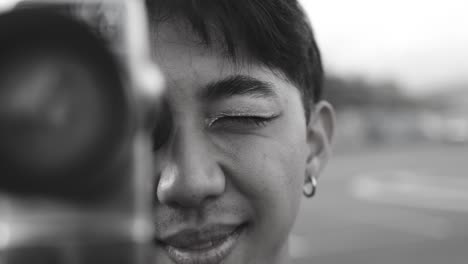 young asian man using vintage old video camera outdoor