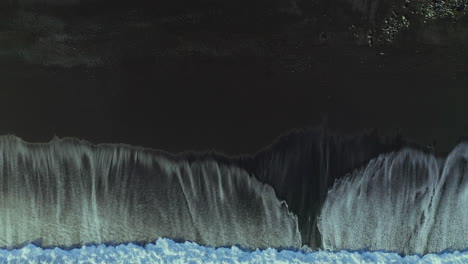 Foamy-Sea-Water-On-Black-Sand-Beach---aerial,-top-down