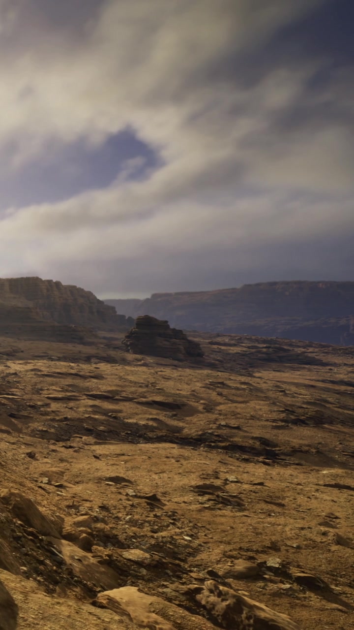 Scenic view of rocky landscape with clouds and distant cliffs at sunset