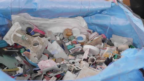 hands sorting out scraps of plastic waste products collected from the ocean