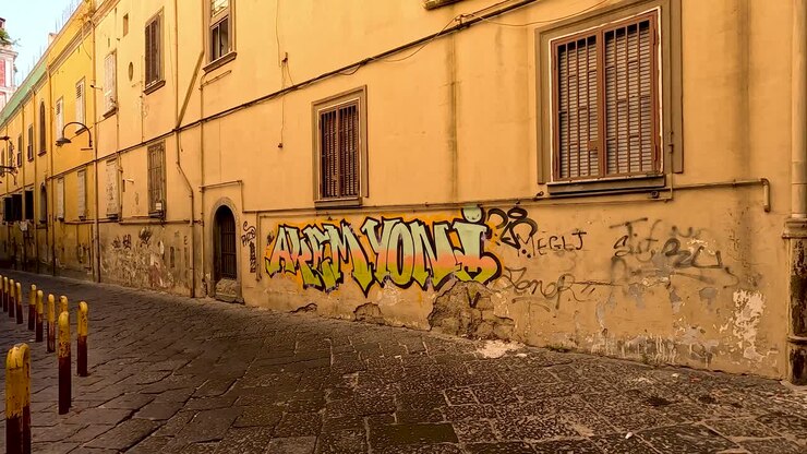 Graffiti su edificio giallo in vicolo stretto