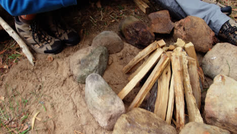 un par de excursionistas preparando un fuego de campamento