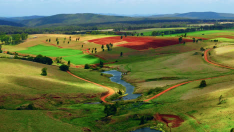 aerial view over colorful fields and creeks in atherton tablelands, queensland, australia - drone shot