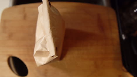 Top-down-shot-of-man-setting-down-coffee-bag-and-coffee-grinder