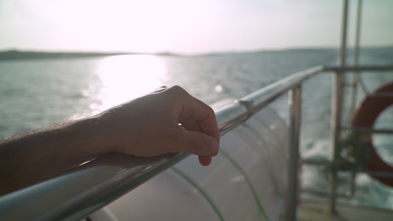 바닷물에서 항해하는 보트 난간에 손을 가까이 대다