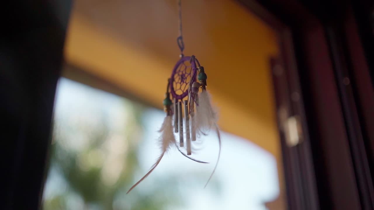 Dreamcatcher hanging from a window HFR