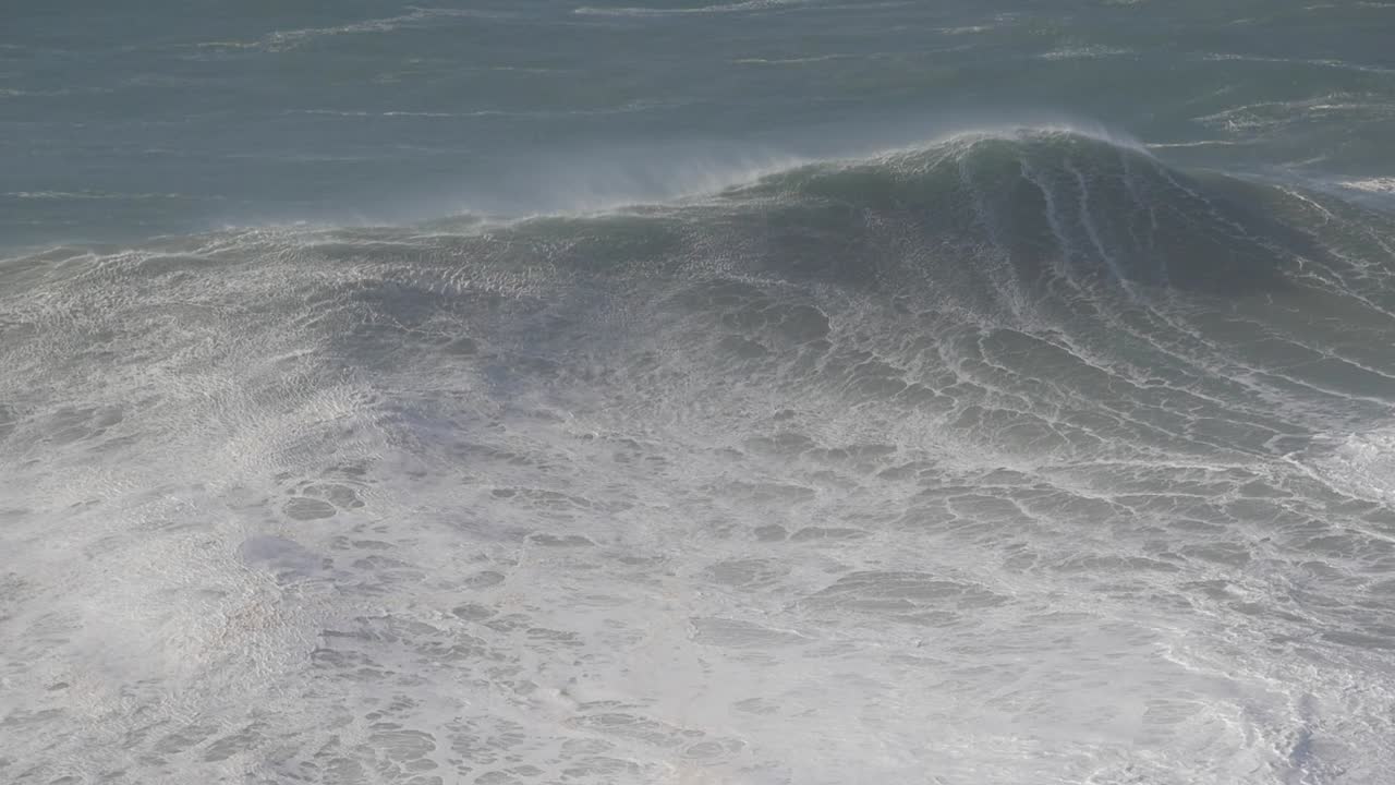 Enormous waves crashing at Praia do Norte, Nazaré, Portugal, in a dynamic scene