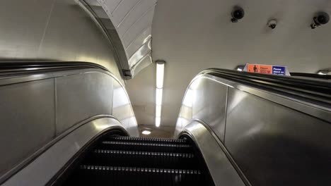 ascending escalator in a busy london station