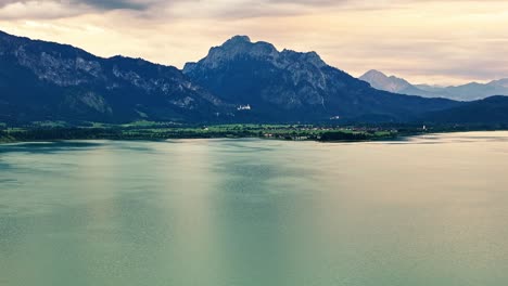 Fast-aerial-zoom-out-from-high-mountains-back-to-a-huge-lake-in-the-foreground