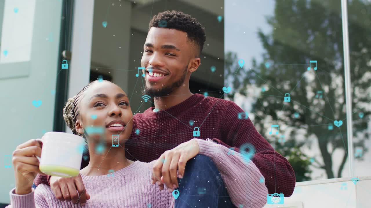 Coppia seduta in veranda, icone che emergono all'inizio e visualizzano una connessione tecnologica sopra una tazza e i volti