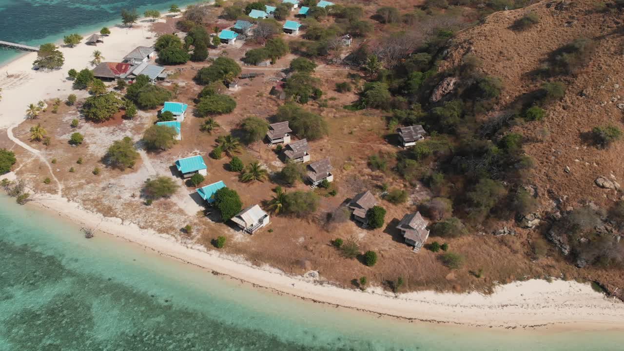 Aerial drone shot of an island revealing an amazing turquoise ocean water with coral reefs