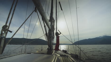 woman in red dress on a sailboat deck at sunset