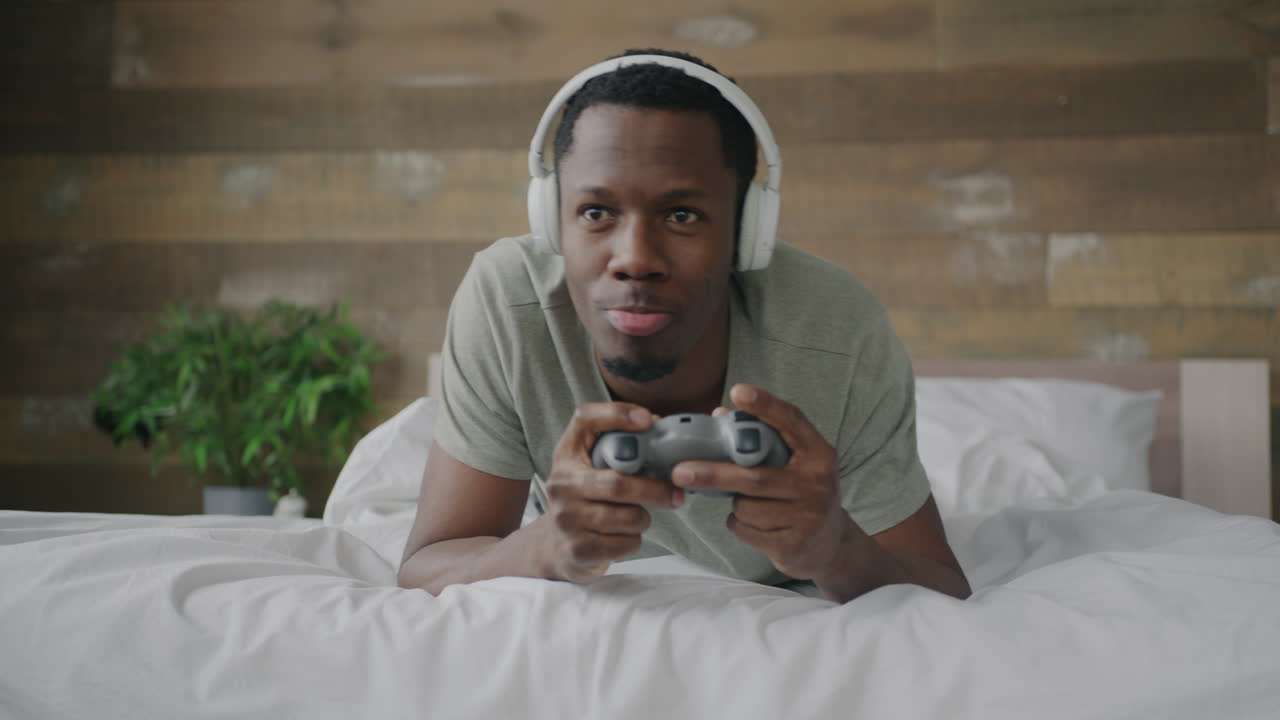 uomo che gioca a videogiochi a letto