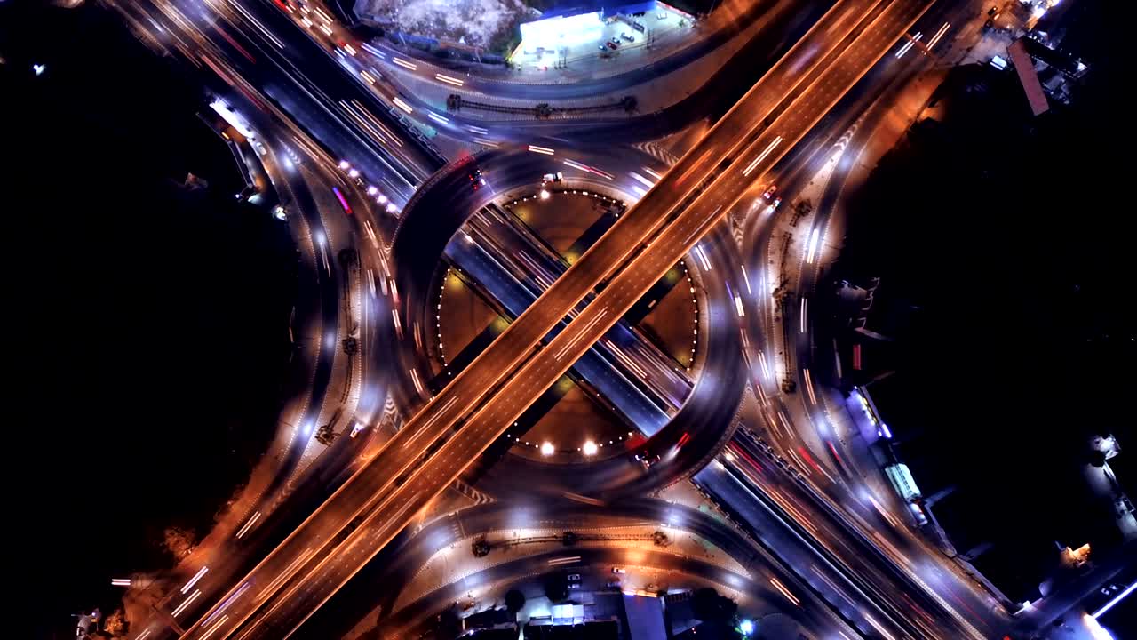 lapso de tiempo de vista aérea de cruces de carreteras con rotonda. carreteras puente forma círculo en la estructura de la arquitectura y el concepto de transporte. vista superior. ciudad urbana, bangkok por la noche, tailandia.