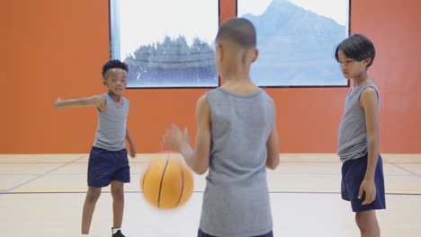 playing basketball in school gym, three boys practicing together in uniforms