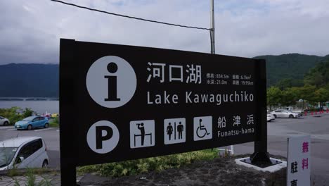 Lake-Kawaguchiko-establishing-shot-panning-over-parking-lot-sign,-Japan