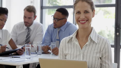 close up on a businesswoman smiling and using a laptop