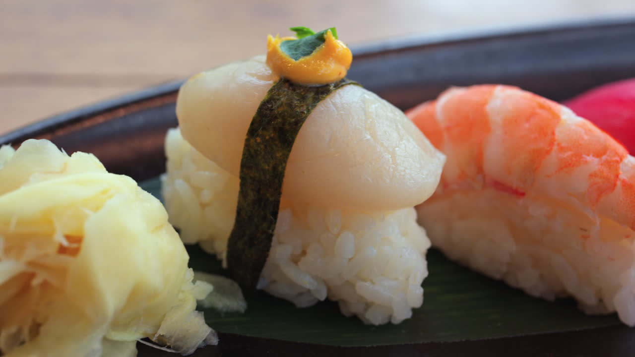 Primo piano di più nigiri su un vassoio nero in un ristorante