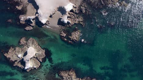 Aerial-pan-over-dramatic-white-seacliffs,-algae,-seaweed,-incredible-benthos
