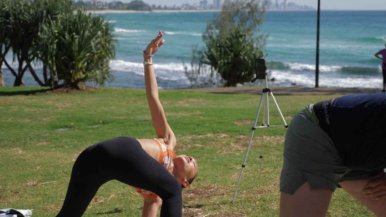 instructor de yoga haciendo la preparación para la pose del triángulo invertido en burleigh hill - queensland, australia - tiro completo en cámara lenta