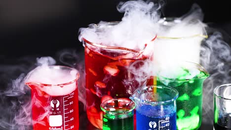 beakers with colorful liquids and rising smoke