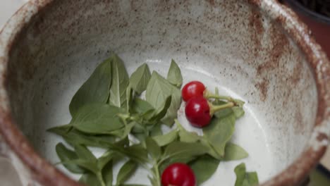 poner hojas de albahaca y chile habanero en un tazón para cubrir la pizza
