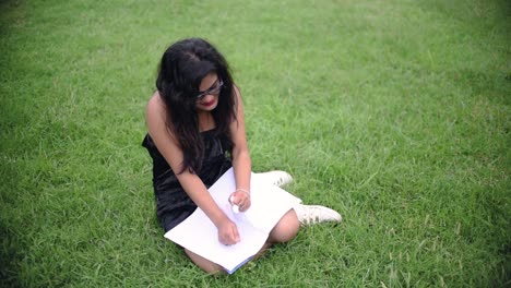 A-depressed-hot-Asian-girl-is-tearing-the-pages-of-a-notebook-with-anger-and-throwing-it-on-the-ground-due-to-breakup,-Slow-motion