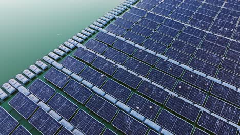 solar panels float in symmetry on green water surface in peaceful aerial shot