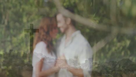 couple standing holding hands in forest, with tech overlay featuring rocky coastline and cross