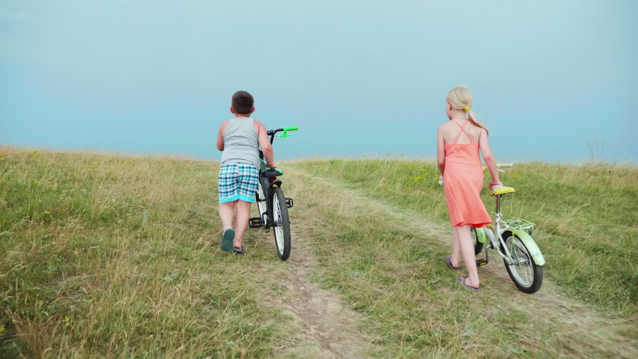 두 아이가 자전거를 타고 언덕을 오르고 있다 2