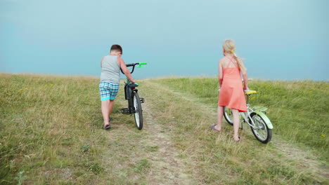Two-Children-Drive-Their-Bikes-Up-The-Hill-2