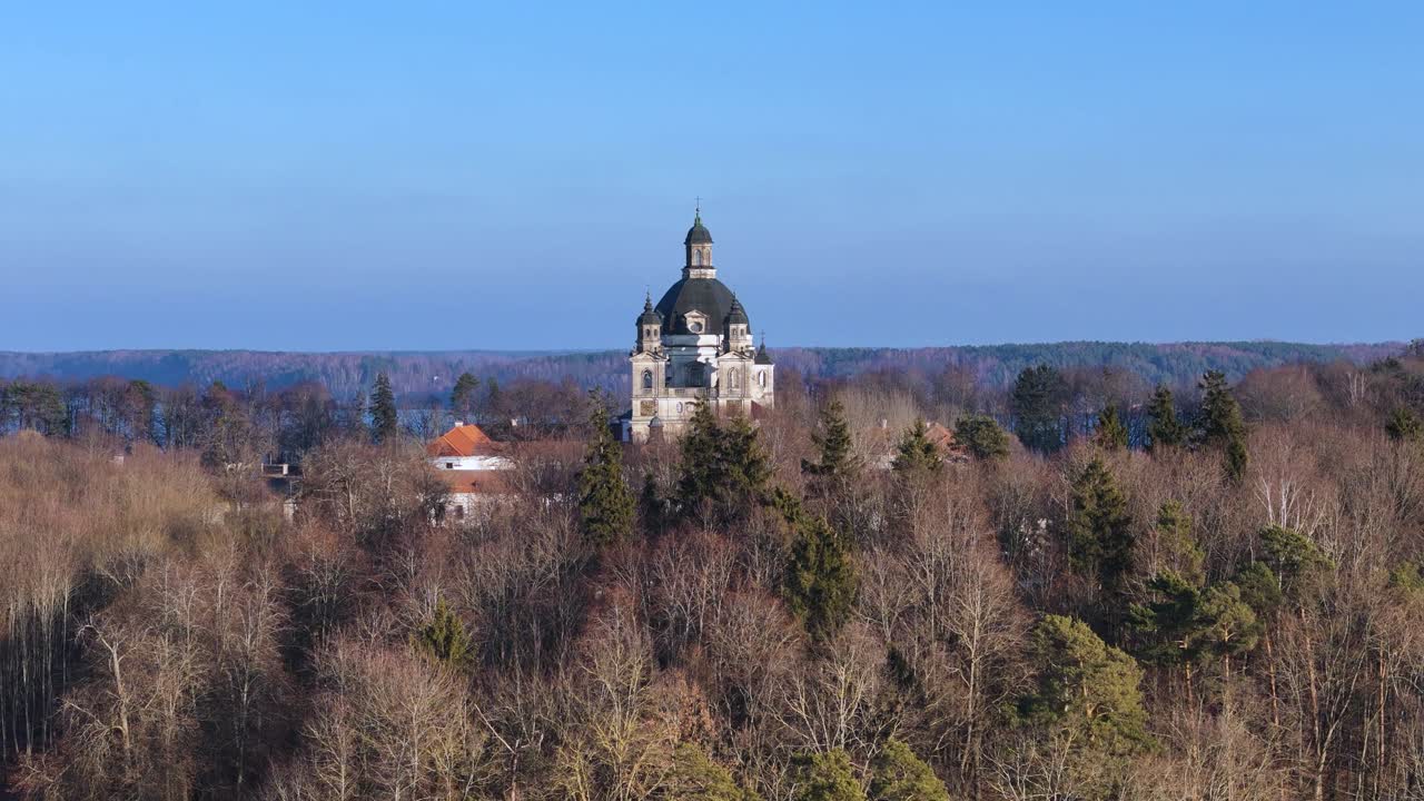 Aerial dolly in view towards the dome of Pazaislis Monastery in Kaunas forest