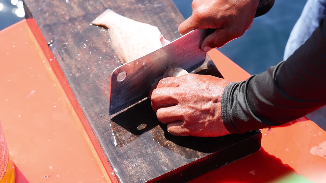 Person filleting fish on a cutting board