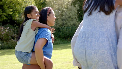 playing outdoors, mother giving child piggyback ride, smiling and enjoying family time