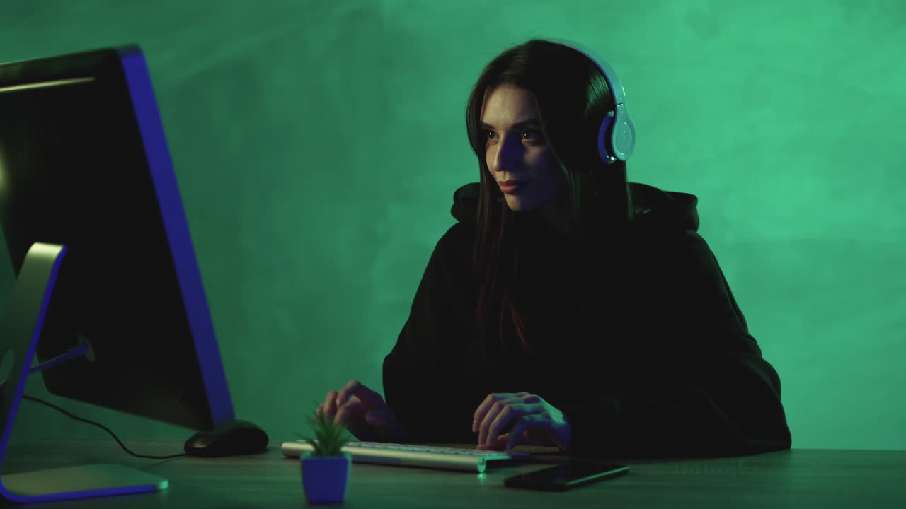 Female working with a computer and wireless headphones on a green colorful background