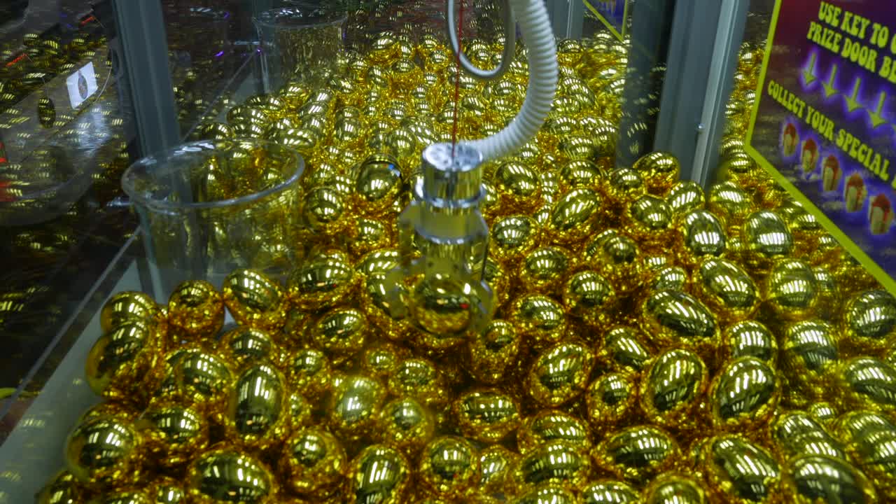 상금과 함께 황금 알을 잡는 아케이드의 클로 그래버 기계