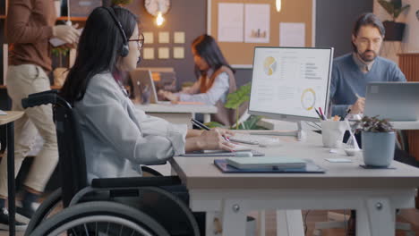 businesswoman in wheelchair working in modern office
