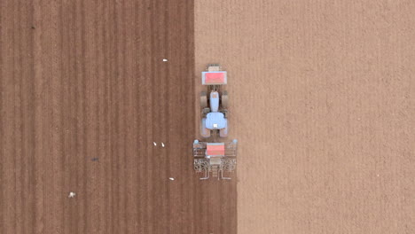 aerial tracking closer shot from above and looking directly down at a tractor as it ploughs a field, aberdeenshire, scotland