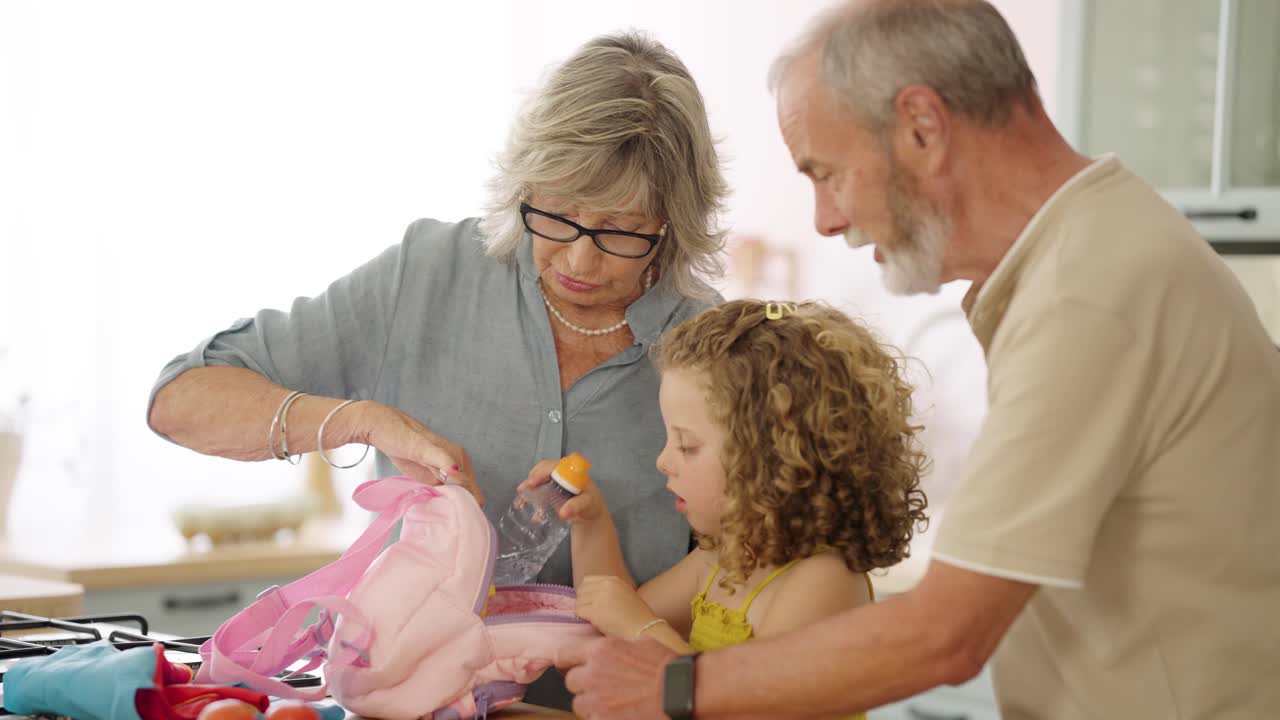 Grandparents helping child pack lunchbox