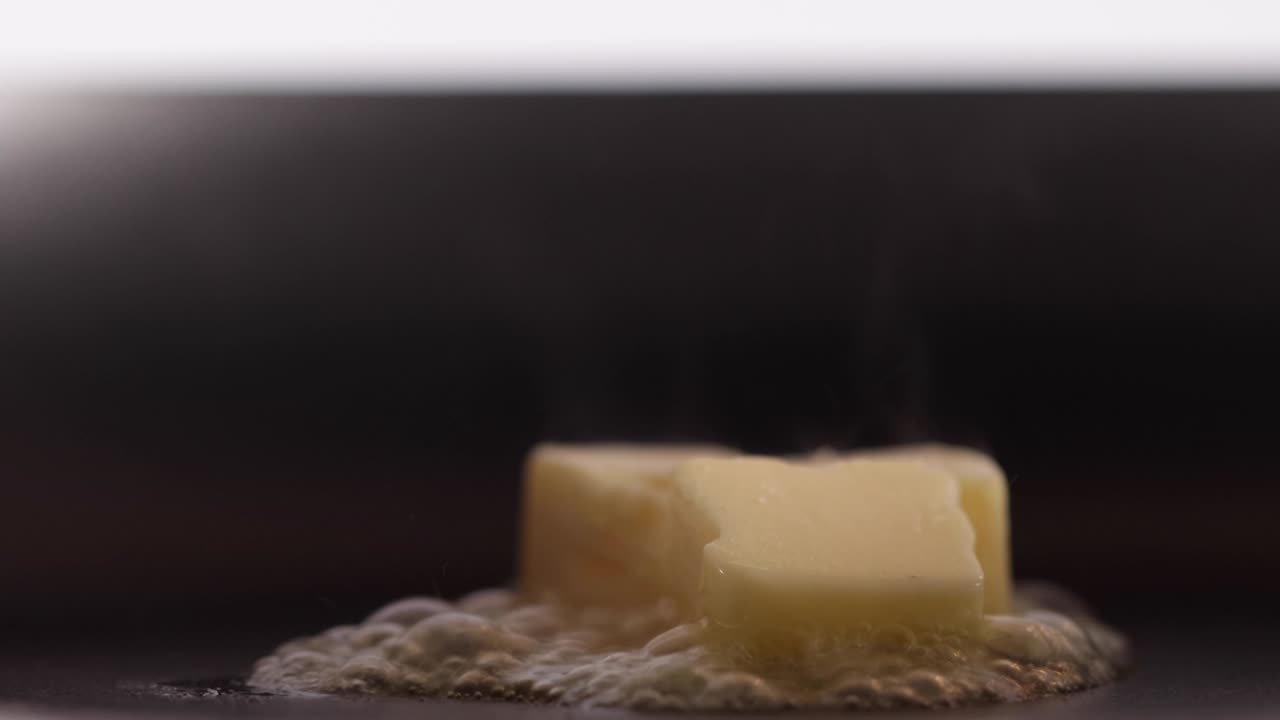 Loop of Butter melting on heated non stick pan.