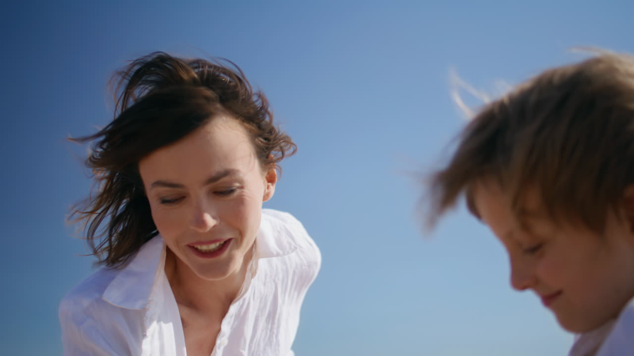 Mother admire playing son spending time together at sunny windy nature closeup