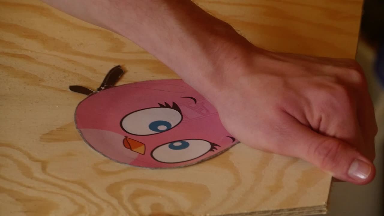 Un personaggio di Angry Birds viene segato da una lastra di legno.