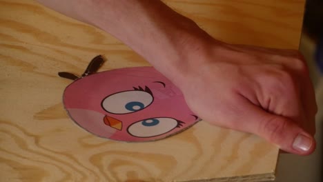 Eine-Figur-Aus-Angry-Birds-Wird-Aus-Einer-Holzplatte-Gesägt