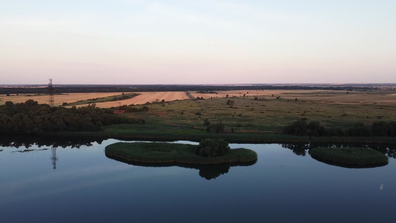 vista aérea de un lago y las tierras de cultivo circundantes al atardecer