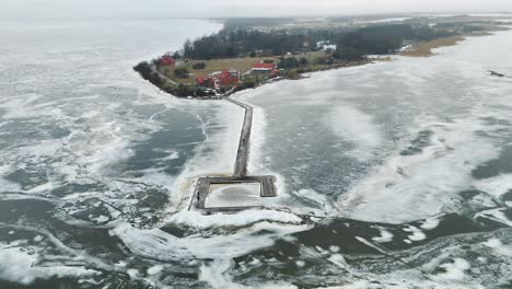 El-Cabo-Ventes-Y-La-Laguna-Congelada-De-Curlandia-En-Lituania-Durante-El-Invierno,-Con-Un-Faro,-Vista-Aérea