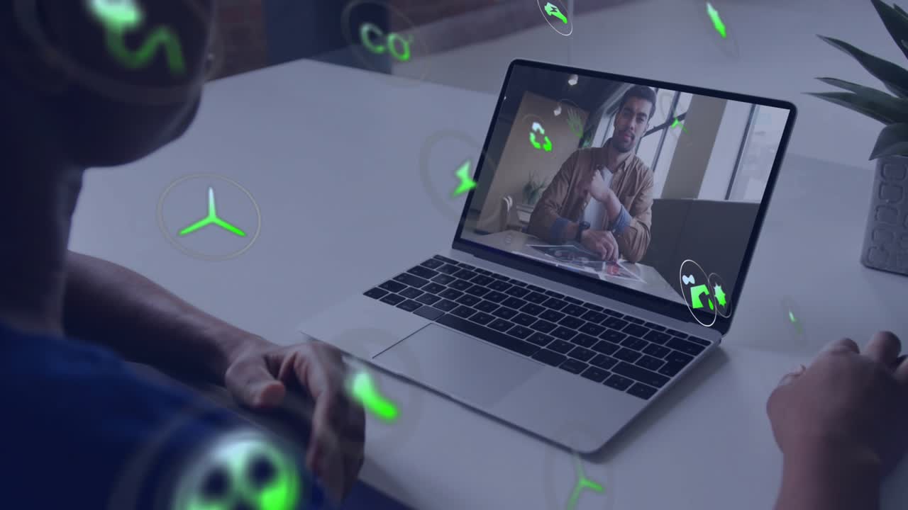 Ekranda teknoloji sunumu yapan bir adam varken elini kaldıran bir kadın, laptop etrafında dönen eko simgelerini başlatıyor