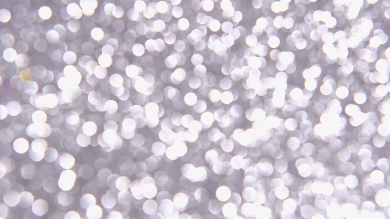fondo de navidad blanco, plateado, gris de año nuevo con luces desfocalizadas brillantes y brillantes. fondo festivo. luces blancas o plateadas en un fondo plateado. videoclip hd